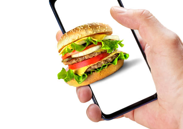 istock Online ordering fast food. Hand holding phone with hamburger on screen 1314791452