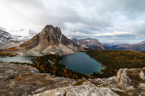 istock looking down at a valley in the mountains with clouds and a lake in the front 1314791863