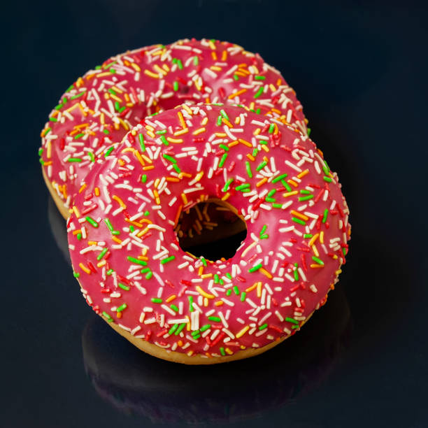 istock Two bright glazed donuts on dark minimal background, top view 1314793608