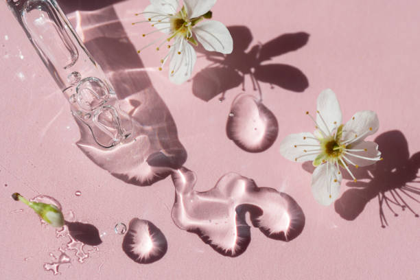primer plano de pipeta rosa con suero líquido con sombras sobre fondo rosa pastel - cherry blossom flower head spring flower fotografías e imágenes de stock
