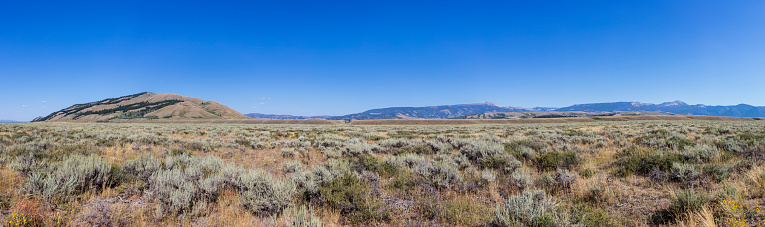 Teton County, Wyoming, United States. Along the U.S. Highway 89, landscape north of Jackson, with prairie, mountains, and sagebrush shrubs in the foreground.