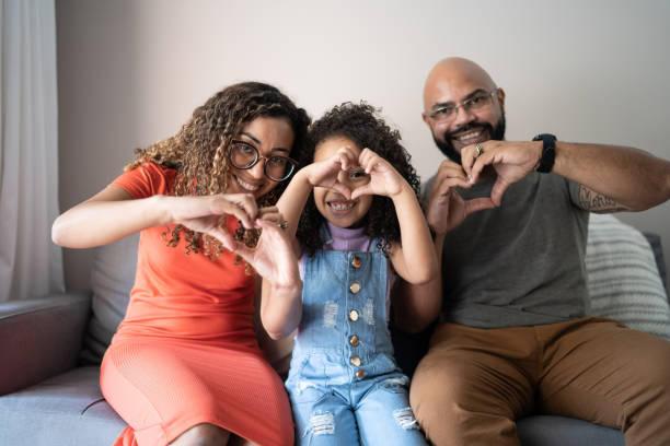 Portrait of a family doing heart-shape with hands at home Portrait of a family doing heart-shape with hands at home heart hands multicultural women stock pictures, royalty-free photos & images
