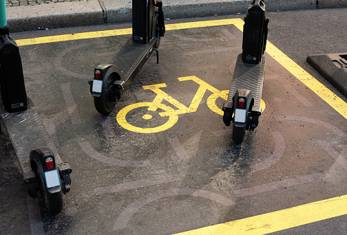 Yellow sign for public bicycle parking on the pavement.