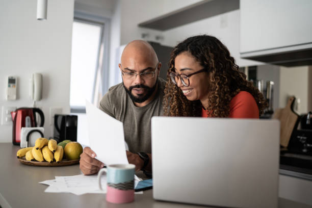 coppia che fa finanze a casa insieme a casa - home finances couple computer african ethnicity foto e immagini stock