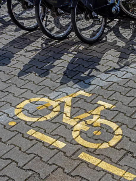 Yellow parking sign for bicycles on the pavement.