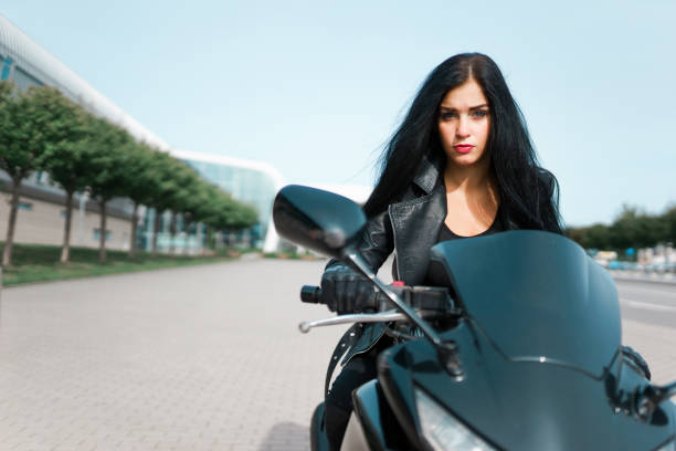 Beautiful girl biker is sitting on his motorcycle.