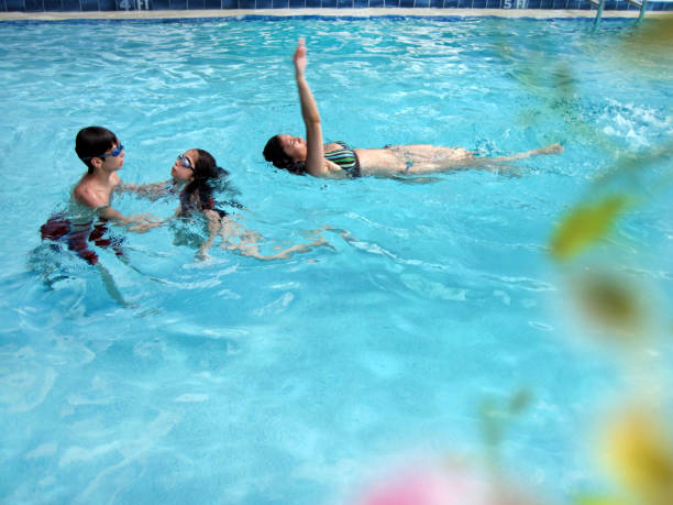 istock Mother and children fun in swimming pool 1314805834