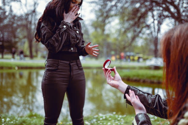 Newly engaged couple hugging moments after she said yes with the man still holding the ring in its ring bax.