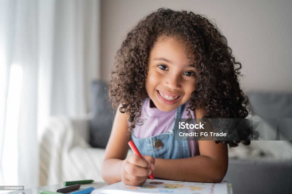 Portrait of a happy girl studying at home Girls Stock Photo