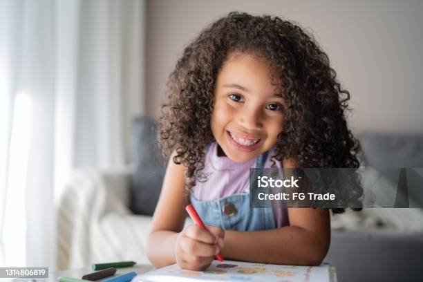 Portrait Of A Happy Girl Studying At Home Stock Photo - Download Image Now - Girls, Crayon, Child