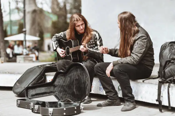 Two Male Metalheads Having Fun In Park And Busking