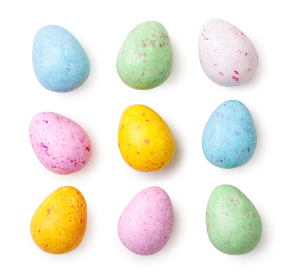 Small speckled multicolored chocolate eggs set close-up on a white background, isolated. Top view
