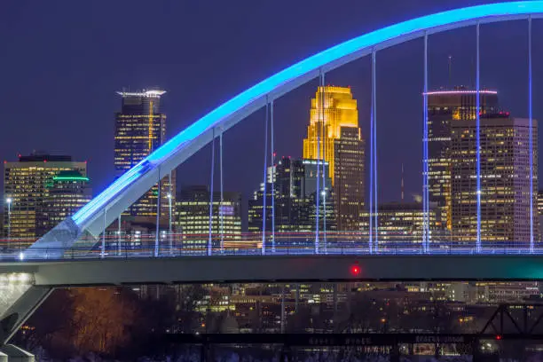 A Telephoto Close Up Shot of Minneapolis Skyscrapers Behind Long Exposure Traffic on the Blue Lowry Bridge at Night