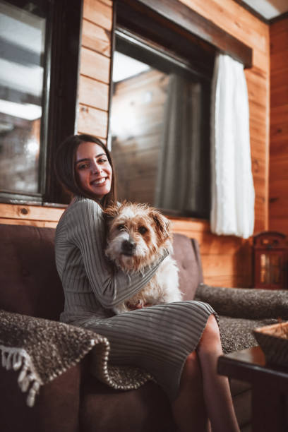 istock Cute Smiling Female Spending Time With Pet Dog On Sofa 1314810257