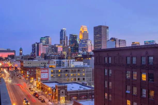 A Wide Angle Shot of Downtown Minneapolis Reflecting Pink Dusk Light as North Loop Traffic Passes in the Foreground