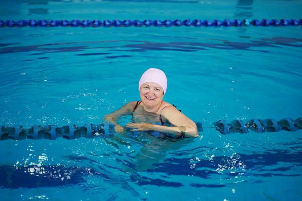 istock Happy middle aged woman in a swimming pool 1314810547