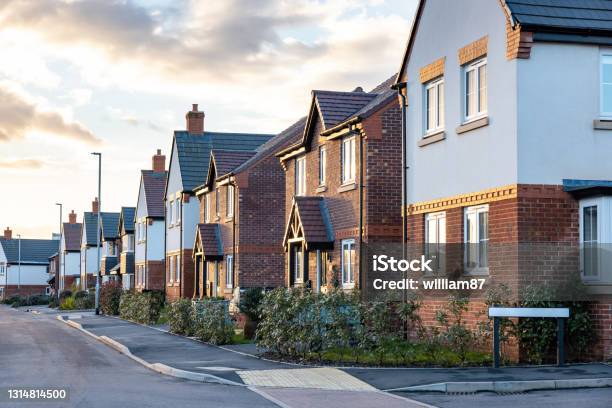 Houses In England With Typical Red Bricks At Sunset Main Street In A New Estate With Typical British Houses On The Side Real Estate And Buildings Concepts In Uk Stock Photo - Download Image Now