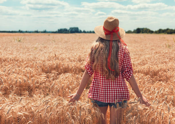 istock Young beautiful girl walking through wheat field 1314817469