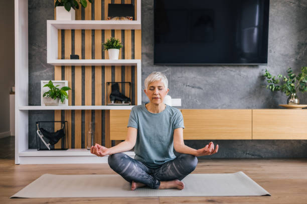 istock Fit senior woman practicing yoga at home. 1314817513