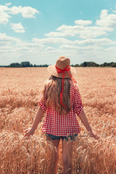 istock Young beautiful girl walking through wheat field 1314817526