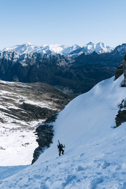 istock Ski mountaineer with splitboard climbs steep snow slope 1314818204
