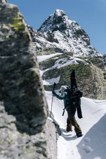 istock Ski mountaineer with splitboard climbs steep snow slope 1314818233