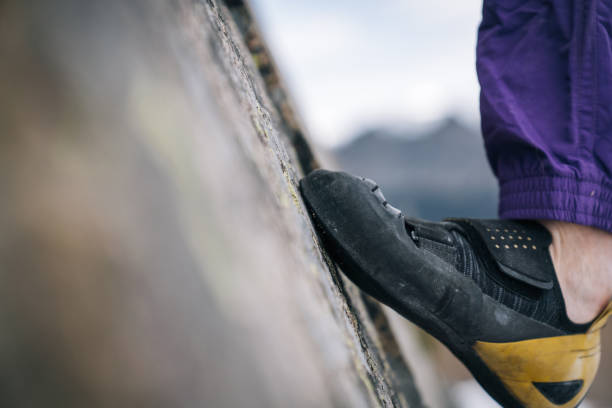 climbers feet ascends steep boulder in snowy field - conquering adversity wilderness area aspirations achievement imagens e fotografias de stock