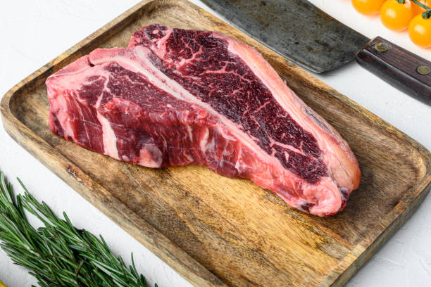 raw fresh meat t-bone steak with spices, garlic and rosemary, on white stone  background - veal t bone steak raw steak imagens e fotografias de stock