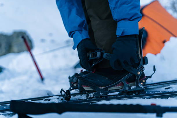 szczegóły splitboarder wprowadzenie wiązania na kempingu zimowym - human hand sheltering men making zdjęcia i obrazy z banku zdjęć