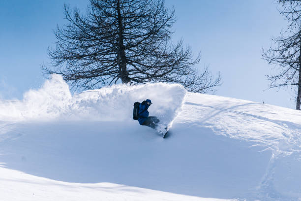 сплитбордер спускается по крутому склону порошка в горах - climbing individual sports sports and fitness snowboard стоковые фото и изображения