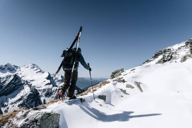 istock Ski mountaineer with splitboard climbs up mountain 1314820494