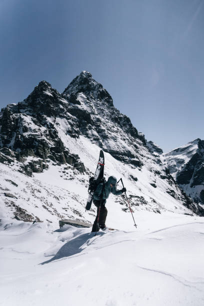 istock Ski mountaineer with splitboard climbs up mountain 1314820547