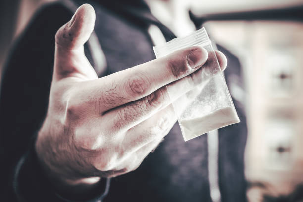Dealing Drugs By A Man Holding A Little Bag With White Powder In His Hand Dealing Drugs By A Man Holding One Little Bag With White Powder In His Hand cocaine photos stock pictures, royalty-free photos & images