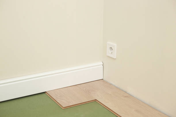 istock Installing wooden laminate or parquet floor in room over green base. assembling panels quickly and easily - affordable flooring. laying laminate flooring at home 1314825563