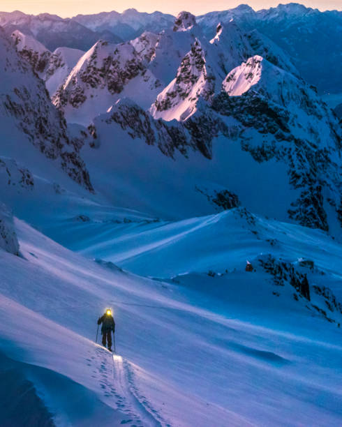 istock Ski mountaineer with headlamp climbs snowy mountain slope 1314825757