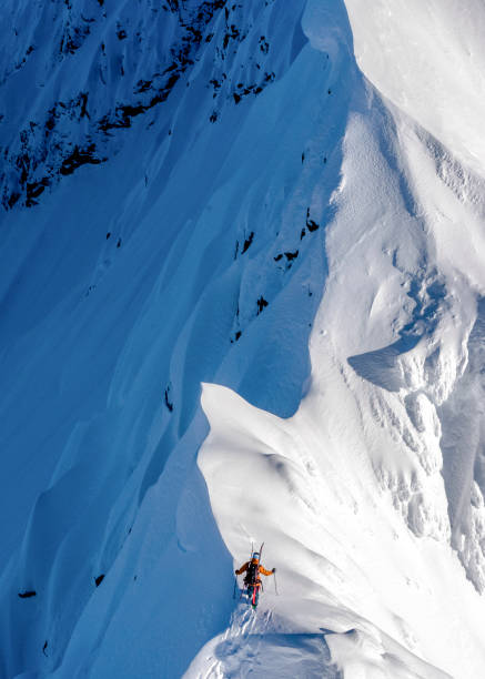 istock Ski mountaineer climbs snowy mountain ridge crest 1314826032
