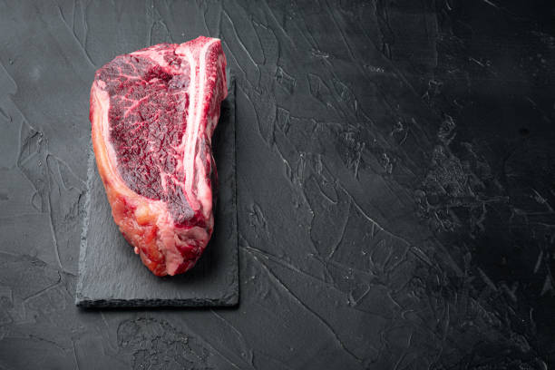 istock Raw fresh meat dry aged Club Steak, on black stone background, with copy space for text 1314828035