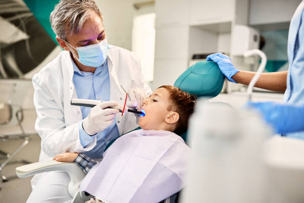 istock Small boy having dental filling drying procedure with curing UV light during dental appointment. 1314828826