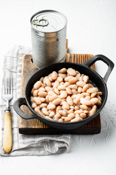 istock White canned beans, with metal can, in cast iron frying pan, on white stone  surface 1314830447