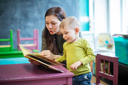 Mother reading to little boy at the library