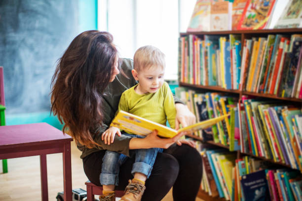 istock Mother reading to little boy at the library 1314831564