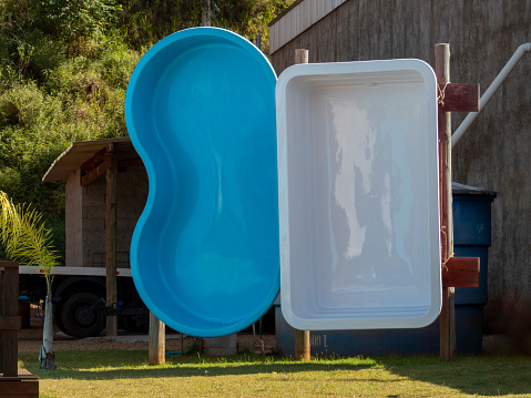 white and blue fiberglass pools exposed for sale.