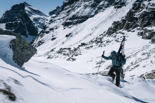 istock Ski mountaineer with splitboard climbs up mountain 1314833462