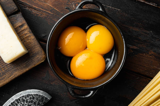 istock Bright yellow egg yolks, on old dark  wooden table , top view flat lay 1314834781