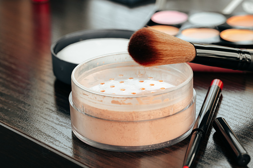 Open loose powder container on table close up photo