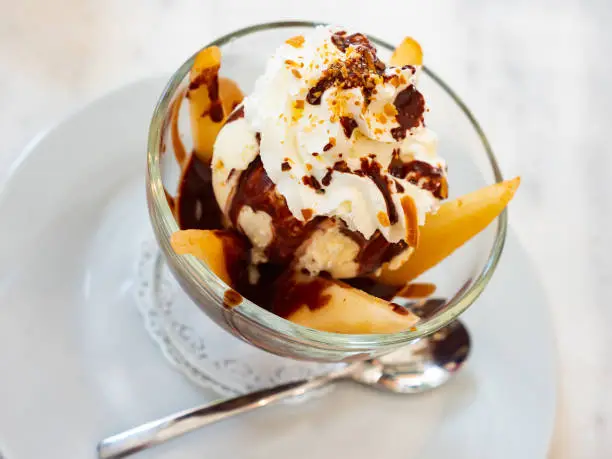 Photo of French dessert Poire belle Helene of poached pears with ice cream