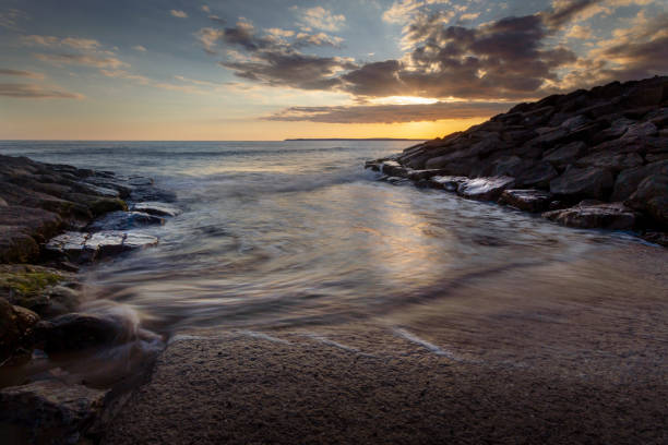 Sunset at Aberavon beach on an incoming tide in Port Talbot, South Wales, UK
