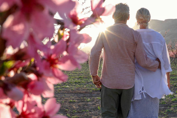 istock View past blossoms to mature couple exploring orchard 1314847557