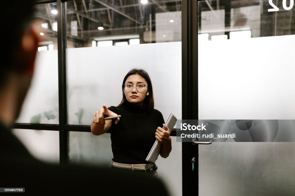 Businesswoman pointing at employee Businesswoman annoyed with her employee Bossy Stock Photo