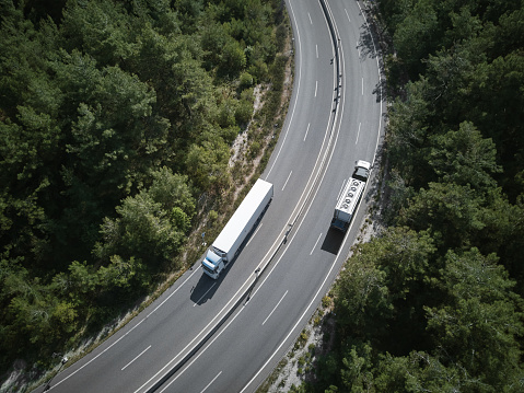 Top view of freight trucks crossing mountain roads